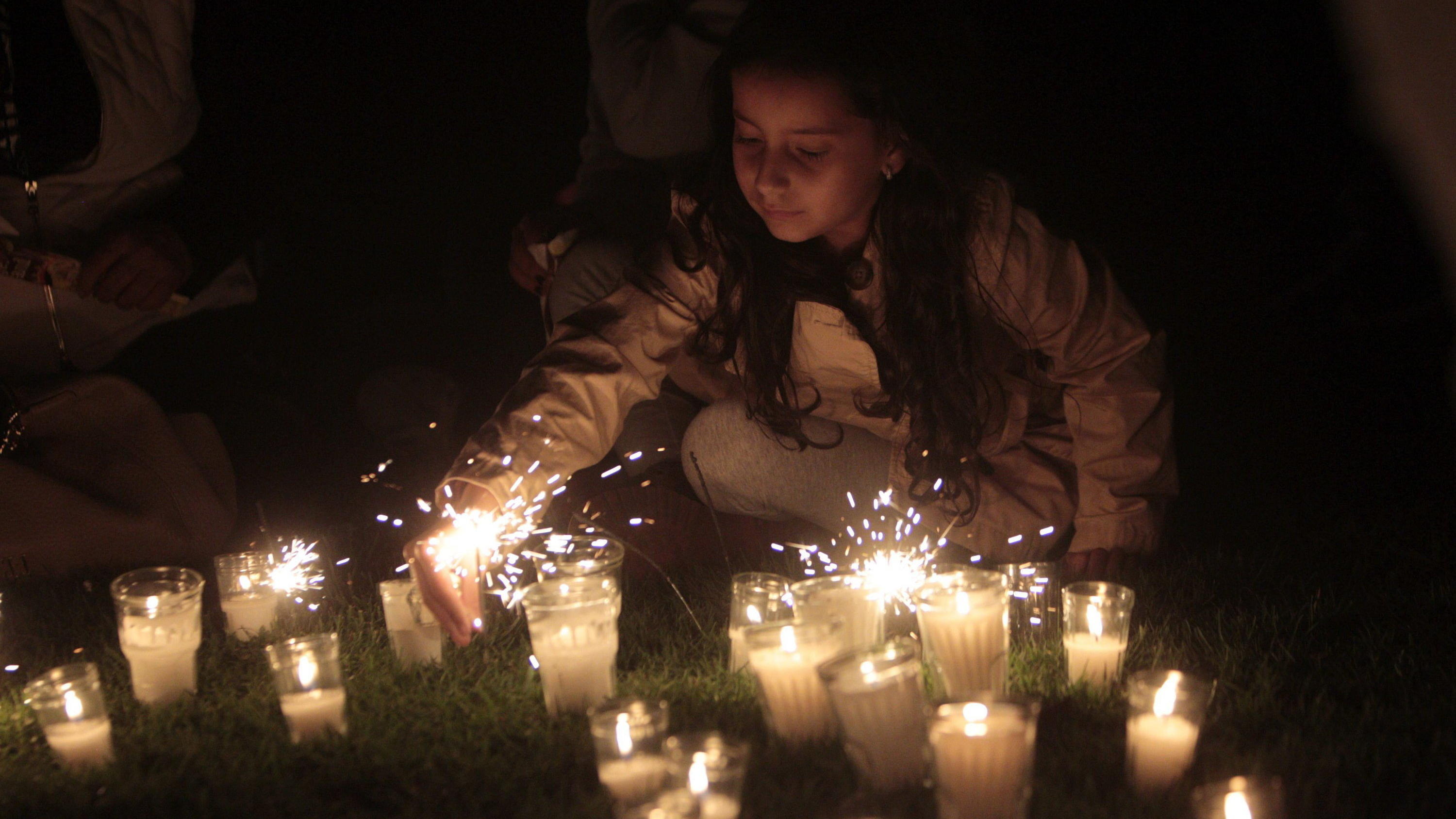 epa04684748 A girl places a candle during the 'Earth Hour' event in Guatemala City, Guatemala, 28 March 2015. Earth Hour takes place worldwide at 8.30 pm local time and is a global call to turn off lights for 60 minutes to raise awareness of the dang