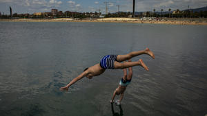 17.06.2020, Spanien, Barcelona: Zwei Jungen springen bei warmem Wetter von einer Mole in Barcelona ins Wasser. Foto: Emilio Morenatti/AP/dpa +++ dpa-Bildfunk +++