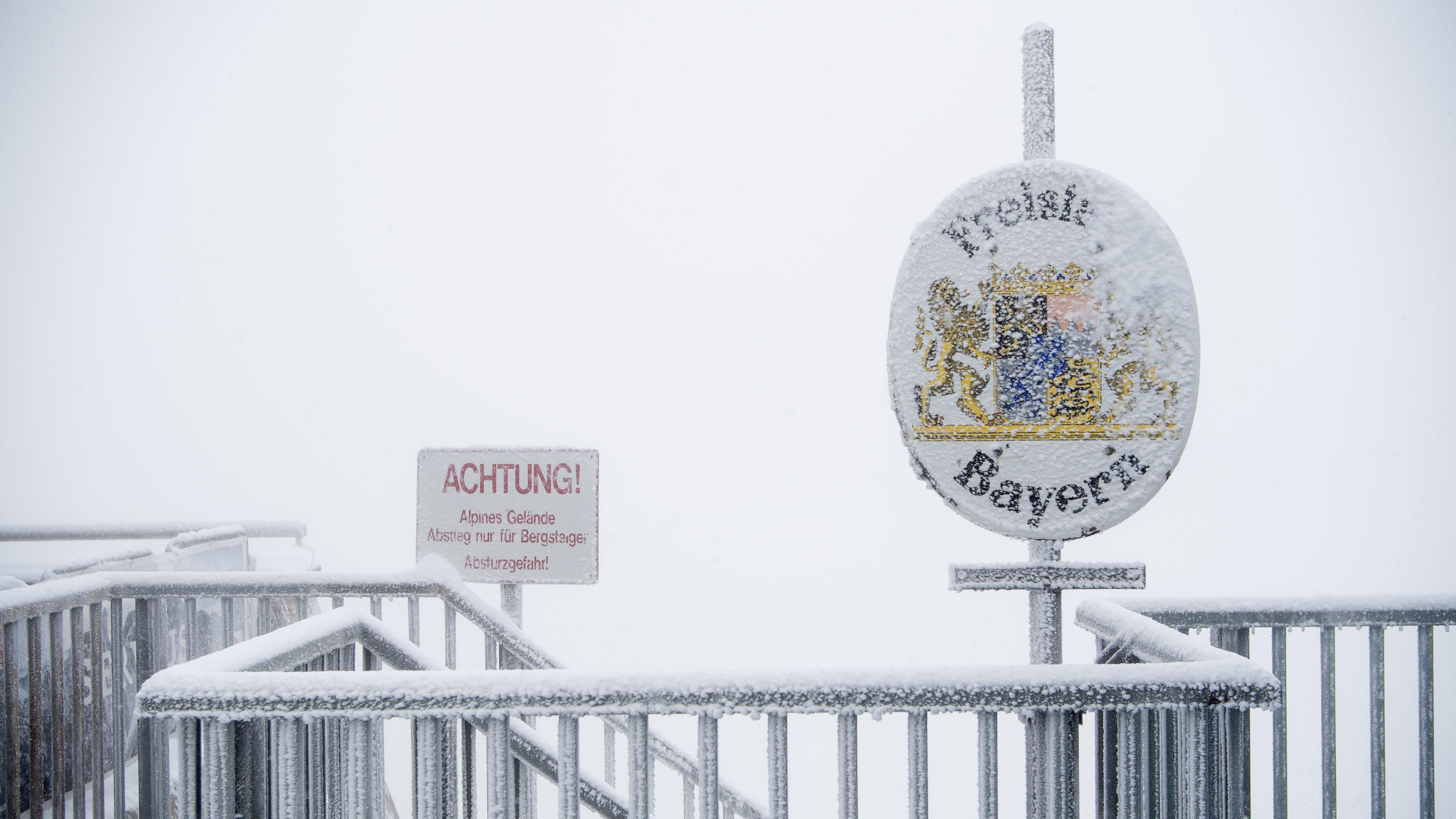 dpatopbilder - 26.08.2018, Bayern, Grainau: Schnee und Eis bedecken auf dem Gipfel der Zugspitze ein Schild mit der Aufschrift "Freistaat Bayern". Foto: Sven Hoppe/dpa +++ dpa-Bildfunk +++