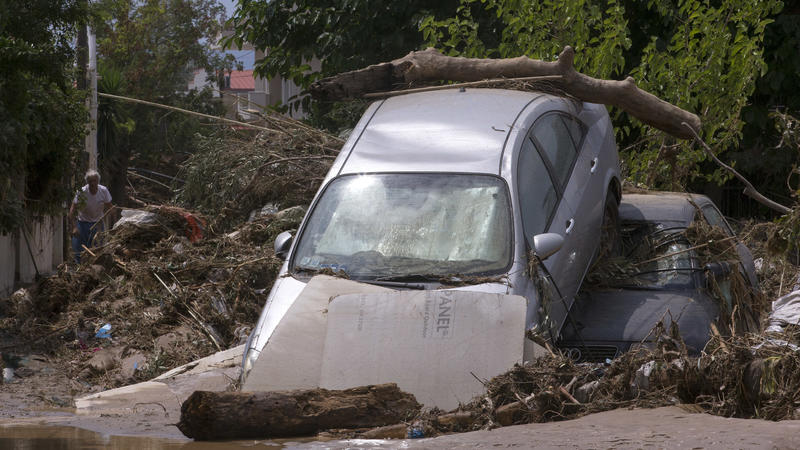 09.08.2020, Griechenland, Evia Island: Zwei Autos sind von einem Sturm ineinander geschoben worden. Schlamm und Geröll umgeben die Fahrzeuge. Wärmegewitter mit schweren Regenfällen haben mindestens sieben Menschen in Griechenland das Leben gekostet. 