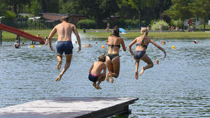 09.08.2020, Sachsen, Radebeul: Badegäste springen im Naturbad Mockritz von einem Steg in das Wasser. Foto: Robert Michael/dpa-Zentralbild/dpa +++ dpa-Bildfunk +++