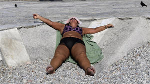 30.08.2020, Griechenland, Athen: Eine Frau sonnt sich an einem Strand im Stadtviertel Paleo Faliro. Durch eine Hitzewelle, die bis zum Dienstag anhalten kann, werden die Temperaturen an einigen Orten Griechenlands auf bis zu 41 Grad Celsius (106 Fahrenheit) ansteigen. Foto: Michael Varaklas/AP/dpa +++ dpa-Bildfunk +++