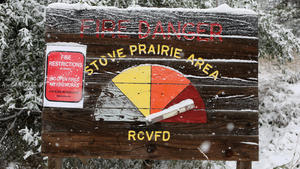 A warning sign lists the fire danger as extreme near a Colorado National Guard staffed roadblock leading to the Cameron Peak wildfire as snow falls a day after the region sweltered through temperatures in the 90s Fahrenheit (32 degrees Celsius) outside Fort Collins, Colorado, U.S., September 8, 2020.  REUTERS/Jim Urquhart     TPX IMAGES OF THE DAY
