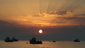 12.08.2020, Großbritannien, Selsey: Die Sonne geht über Fischerbooten vor Selsey in West Sussex im Meer auf. Foto: Andrew Matthews/PA Wire/dpa +++ dpa-Bildfunk +++