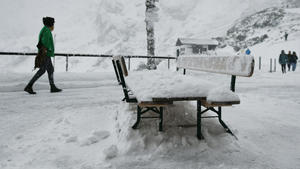dpatopbilder - 26.09.2020, Bayern, Garmisch-Partenkirchen: Eine Frau geht über die verschneite Terrasse der Bergstation am Osterfelderkopf im Wettersteingebirge nach einem Temperatursturz. Foto: Angelika Warmuth/dpa +++ dpa-Bildfunk +++