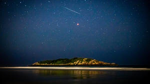  Meteor shooting through the night sky above island in ocean and Mars. Gloucester, MA, United States PUBLICATIONxINxGERxSUIxAUTxONLY CR_ZEFR200819B-476783-01