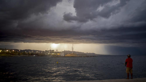  August 30, 2020, Barcelona, Catalonia, Spain: On this Sunday evening, a man fishes from a Barcelona breakwater as a thunderstorm looms on the horizon. Barcelona Spain - ZUMAb137 20200830_zap_b137_006 Copyright: xJordixBoixareux