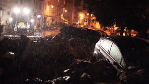 28.11.2020, Italien, Nuoro: Zwei Fahrzeuge stehen halb in Schlammmassen versunken neben einer überfluteten Straße in der Innenstadt. Wassermassen in den Straßen, Tote und ein Brückeneinsturz: Auf der italienischen Mittelmeerinsel Sardinien hat ein Unwetter schwere Schäden angerichtet. Foto: Alessandro Tocco/LaPresse via ZUMA Press/dpa +++ dpa-Bildfunk +++