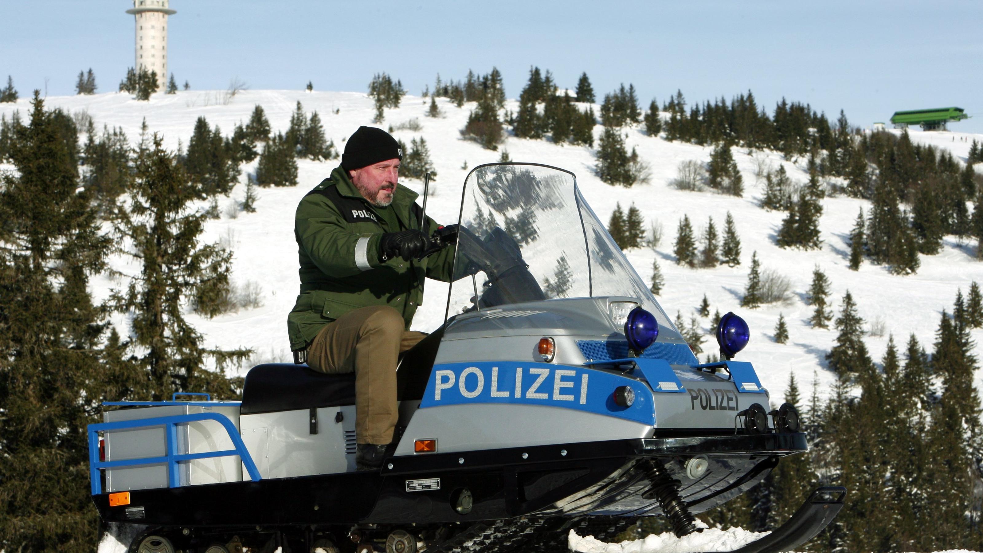 Polizeikommissar Rainer Neubronner fährt am Montag (15.12.2008) mit einem Motor-Schneeschlitten auf einer Skipiste auf dem Feldberg im Hochschwarzwald. Im Hintergrund der Feldbergturm. Mit dem technisch und optisch in blau-silber auf den neuesten Sta