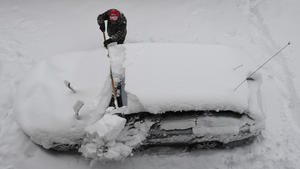 14.01.2021, Bayern, Garmisch-Partenkirchen: Ein Mann versucht sein Auto vom Schnee zu befreien. Innerhalb weniger Stunden sorgte eine Nordstaulage für viel frischen Schnee in den Bergen. Foto: Angelika Warmuth/dpa +++ dpa-Bildfunk +++