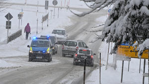 17.01.2021, Bayern, Spitzingsee: Ein Polizeiwagen steht im Tal an der Zufahrt zum Spitzingsee. Aufgabe ist es, die Pkw-Fahrer darauf hinzuweisen, dass die Auf- und Abfahrt zum Spitzingsee sehr verschneit und glatt sind. Foto: Peter Kneffel/dpa +++ dpa-Bildfunk +++
