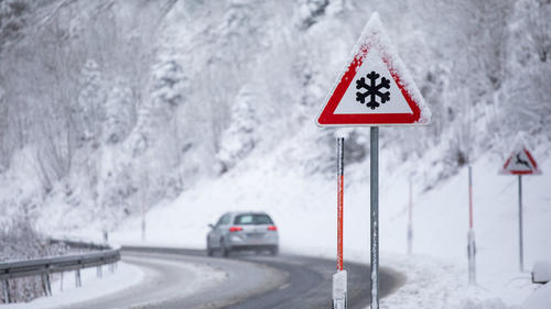 01.12.2020, Baden-Württemberg, Todtnau: Ein PKW fährt auf einer mit Schneematsch bedeckten Straße während im Vordergrund ein Verkehrsschild auf Glättegefahr hinweist. Foto: Philipp von Ditfurth/dpa +++ dpa-Bildfunk +++