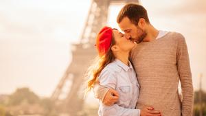 Young loving couple sharing their love and affection in front of the Eiffel tower in Paris, France. 