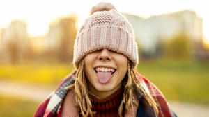 Portrait of young woman wearing warm winter coat, knit hat and scarf outdoors