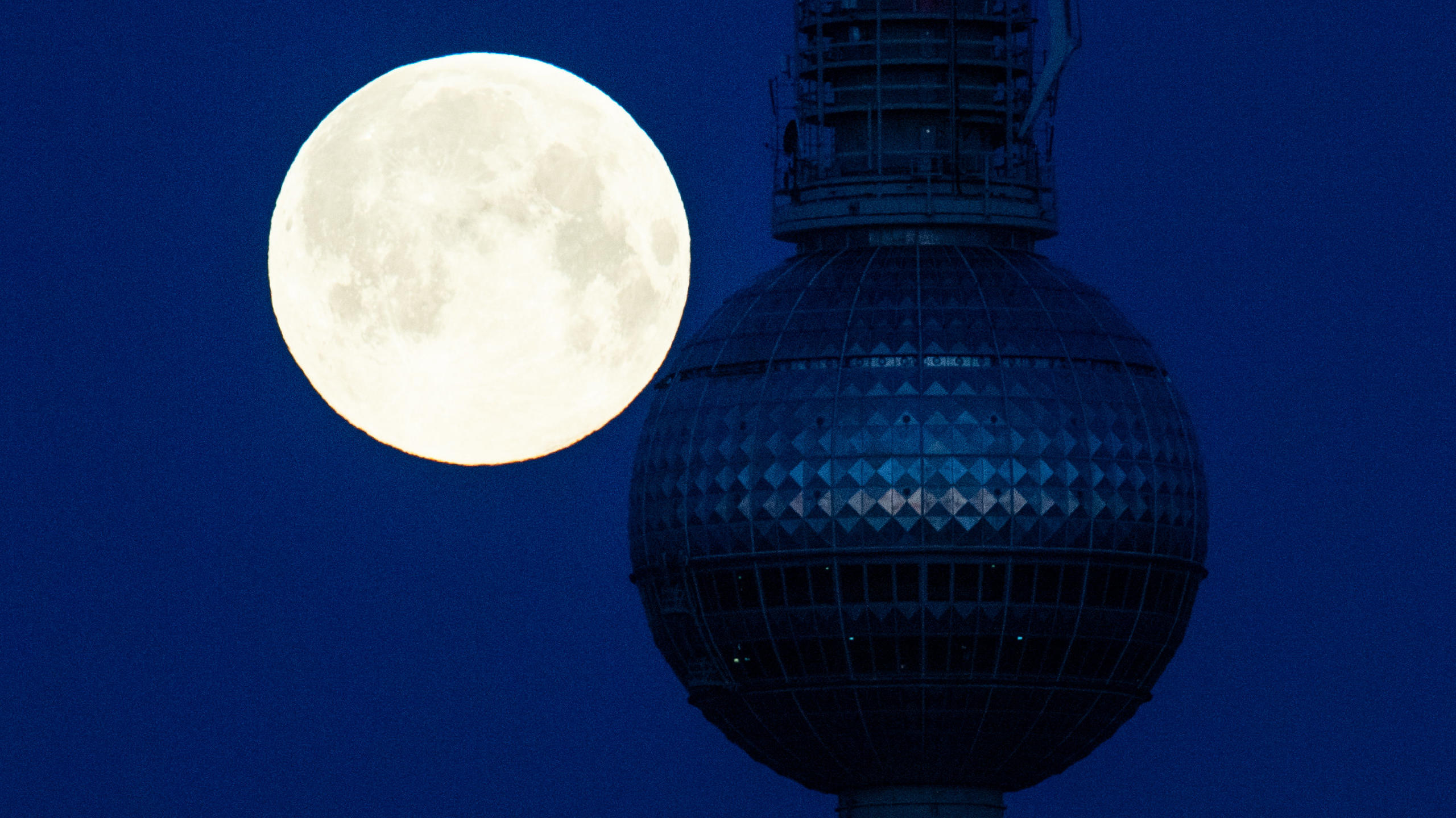 27.04.2021, Berlin: Ein sogenannter Supermond steht hinter dem Fernsehturm. Ein Supermond entsteht, wenn der Mond bei Vollmond der Erde besonders nahe ist. Foto: Christophe Gateau/dpa +++ dpa-Bildfunk +++