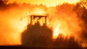 Protest der Gastronomen Ein Traktor pflügt in einer Staubwolke vor den Strahlen der untergehenden Sonne ein Feld zwischen Dresden und Heidenau vor der Aussaat im Frühling. Im Hintergrund eine Ampel, völlig von einer Staubwolke verdüstert. Die Böden der Felder sind noch vor Beginn des Sommers schon sehr ausgetrocknet. *** Protest of the restaurateurs A tractor ploughs a field between Dresden and Heidenau in a cloud of dust before the rays of the setting sun before sowing in spring In the background a traffic light, completely darkened by a cloud of dust The soils of the fields are already very dry before the beginning of summer
