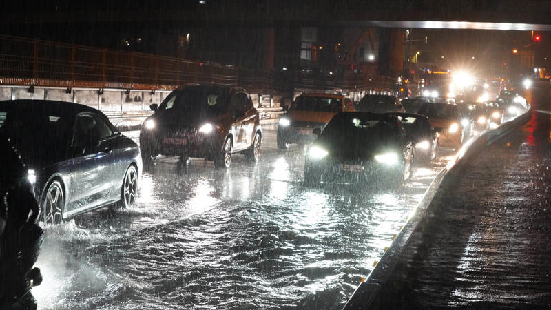 dpatopbilder - 05.06.2021, Baden-Württemberg, Stuttgart: Autos fahren über die überflutete Schillerstrasse am Stuttgarter Hauptbahnhof. Die Abflüsse der Straße konnten die Wassermassen nicht aufnehmen. Foto: Andreas Rosar/dpa +++ dpa-Bildfunk +++