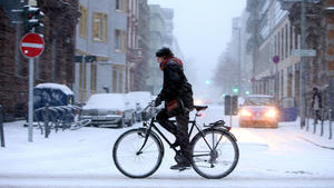 Eine junge Frau fährt am Sonntag (20.12.2009) in Frankfurt am Main mit dem Fahrrad durch das Schneetreiben. Am Nachmittag fielen in Frankfurt mehrere Zentimeter Schnee. Bundesweit sorgten die eisige Kälte und zum Teil heftiger Schneefall für mancherorts chaotische Verkehrsbedingungen. Foto: Marius Becker dpa/lhe  +++(c) dpa - Bildfunk+++