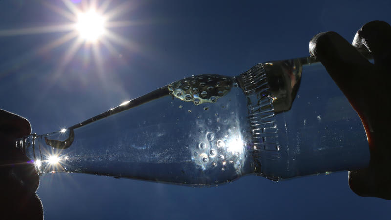 Eine Frau trinkt im Sonnenschein aus einer Flasche sprudelndes Mineralwasser. Draußen ist es richtig heiß - ein kaltes Getränk muss her. Aber ist das eigentlich eine gute Idee? (zu dpa: "Sommer-Fakten gecheckt: Z