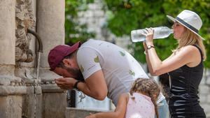  Heat wave in Croatia A man cools off as woman drink cold water at Onofrio fountain during a heat wave in Dubrovnik, Croatia on June 21, 2021. GrgoxJelavic/PIXSELL