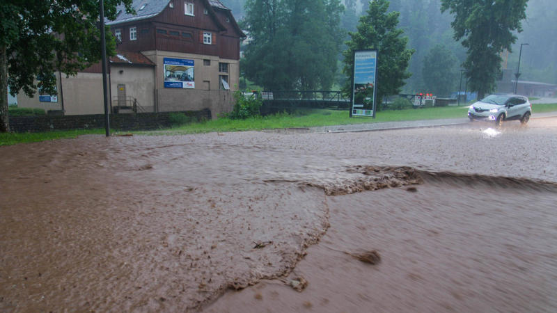Unwetter in Deutschland. Auto auf überfluteter Straße