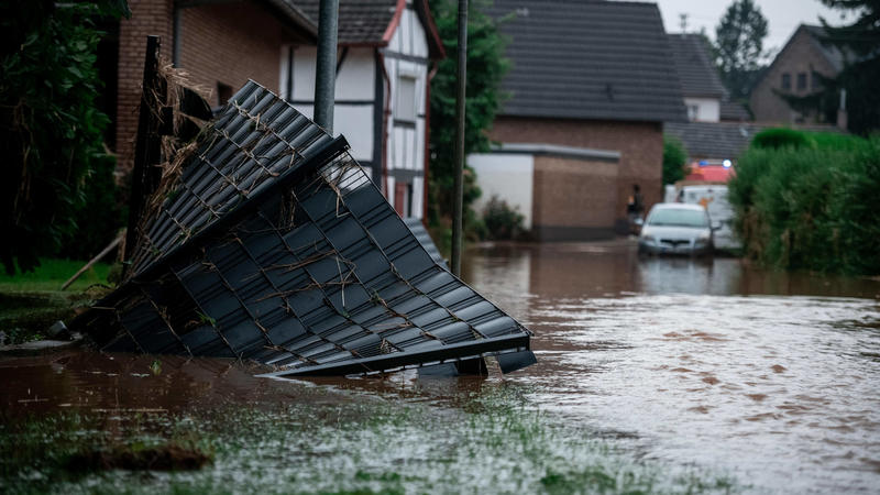 15.07.2021, Nordrhein-Westfalen, Heimerzheim: Ein Gartenzaun liegt im Wasser in Heimerzheim. Die Brauchwasser-Talsperre, deren Damm tiefe Furchen aufweist, ist am Donnerstag von einem Sachverständigen als «sehr instabil» eingestuft worden. Aus Sicher