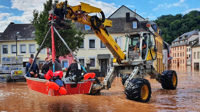 15.07.2021, Nordrhein-Westfalen, Trier: Personen werden mit einem Bagger und einem Boot aus einem überfluteten Teil der Stadt gerettet. Foto: Sebastian Schmitt/dpa +++ dpa-Bildfunk +++