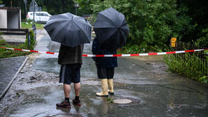 13.07.2021, Bayern, Naila: Zwei Anwohner betrachten die Schäden des übergelaufenen Issigbachs. In Naila und Umgebung kam es wegen starker Regenfälle zum Überlaufen der Selbitz. Foto: Daniel Vogl/dpa +++ dpa-Bildfunk +++