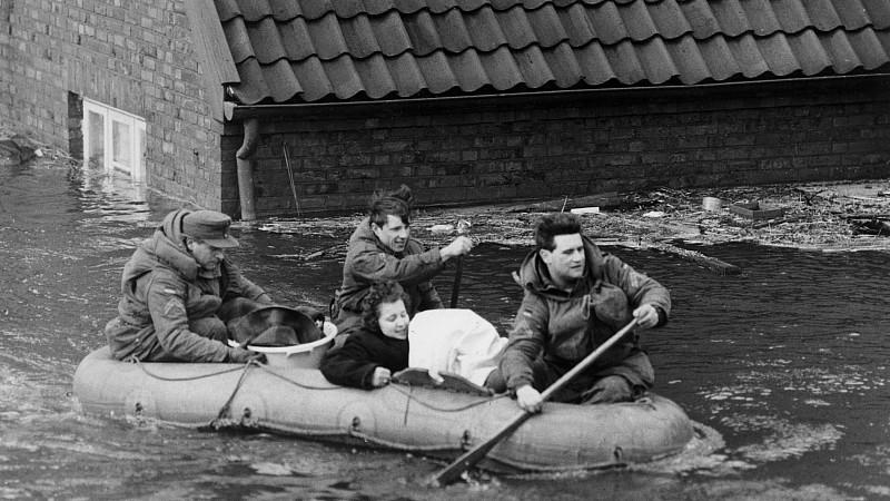 ARCHIV - Eine Frau wird am 17.02.1962 in Hamburg mit einem Schlauchboot in Sicherheit gebracht. Bei der großen Sturmflutkatastrophe in der Nacht vom 16. zum 17. Februar 1962 starben 315 Menschen, davon alleine 200 in dem Hamburger Stadtteil Wilhelmsb