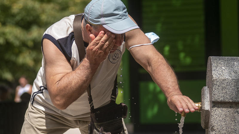 12.08.2021, Spanien, Madrid: Ein Mann versucht, sich in einem Brunnen im Retiro-Park in Madrid abzukühlen.