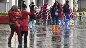 02.11.2021, Italien, Venedig: Menschen fotografieren sich auf dem überfluteten Markusplatz. Wegen Unwettern und starker Winde droht der norditalienischen Lagunenstadt Venedig Hochwasser. Das Flutschutzsystem «Mose» sei deshalb aktiviert worden, schrieb Bürgermeister Brugnaro am späten Montagabend (01.11.2021) auf Twitter. Foto: Matteo Tagliapietra/LaPresse/dpa +++ dpa-Bildfunk +++