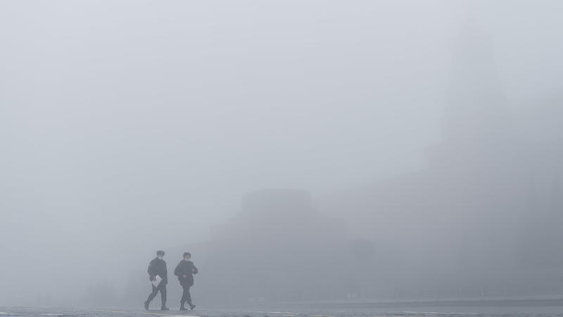 Diese Bild ist aus Russland: Polizisten gehen bei Nebel auf dem Roten Platz