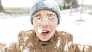 Portrait of boy with snow in his face model released Symbolfoto PUBLICATIONxINxGERxSUIxAUTxHUNxONLY KMKF00708  