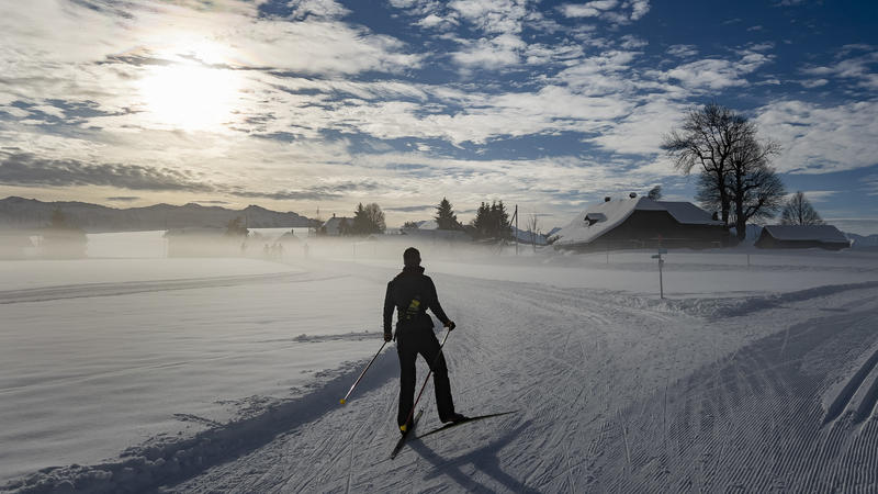 14.12.2021, Schweiz, Heimenschwand: Eine Skilangläuferin fährt bei Sonnenschein auf der Loipe. 