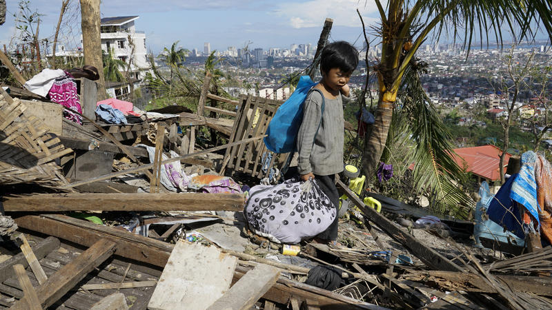 Philippinen, Cebu: Romel Lo-ang holt persönliche Gegenstände aus ihrem durch den Taifun RAI beschädigten Haus. 
