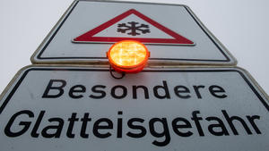 08.12.2021, Bayern, Wittislingen: Ein Straßenschild warnt mit einer Blinkleuchte vor Glatteis. Für den Vormittag wurde im Süden vor Eisregen gewarnt. Foto: Stefan Puchner/dpa +++ dpa-Bildfunk +++