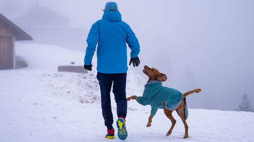 26.12.2021, Bayern, Rottach-Egern: Urlauber Martin Falke geht bei starkem Nebel auf dem Wallberg bei Rottach-Egern mit seinem Hund Miami im Schnee spazieren. Foto: Lennart Preiss/dpa +++ dpa-Bildfunk +++
