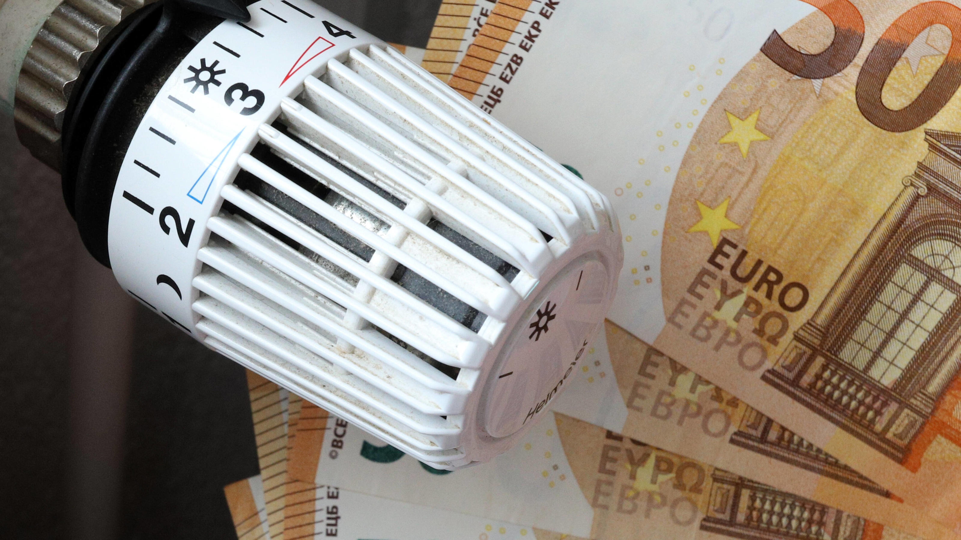 Steigende Inflation - Symbolbilder Die Energiekosten steigen und steigen, Thermostatkopf an einem Heizkoerper mit Geld, Geldscheinen, Euroscheinen Symbolbild zum Thema Energiekosten am 16.10.2021 in Siegen/Deutschland *** The energy costs rise and rise, thermostat head on a radiator with money, banknotes, euro notes symbol picture on the subject of energy costs on 16 10 2021 in Siegen Germany