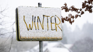 05.01.2022, Nordrhein-Westfalen, Bielefeld: Das Wort ·Winter· ist in den Schnee auf einem Ortsschild geschrieben worden. Das Wetter ist in Teilen von Ostwestfalen winterlich mit Schneefall und Temperaturen um den Gefrierpunkt. Foto: Friso Gentsch/dpa +++ dpa-Bildfunk +++