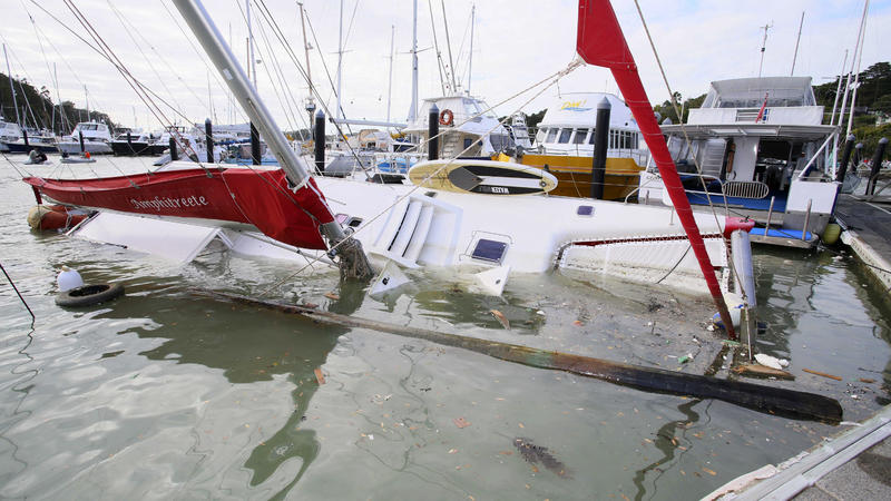 Neuseeland, Tutukaka: Ein Boot droht im Hafen zu kentern, nachdem die Wellen eines Vulkanausbruchs in den Hafen geschwappt waren. 