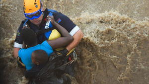 A handout photograph made available 19 January 2012 by the South African Airforce shows a South African Police officer rescuing a South African mother and child from a tree top and prepares them to be hoisted by helicopter from a flood in Mpumalanga, South Africa 18 January 2012. Hundreds of people have been made homeless by heavy flooding in South Africa and Mozambique according to officials. Heavy rain in a short period of time in this part of Southern Africa caused the floods prompting many to seek refuge on rooftops and in trees and an evacuation of the Kruger National Park, a game reserve in northern South Africa. Rescuers have used helicopters to save at least 150 people from submerged houses in the area. EPA/NOEL KLOOPPER /SOUTH AFRICAN AIRFORCE HANDOUT EDITORIAL USE ONLY/NO SALES ++