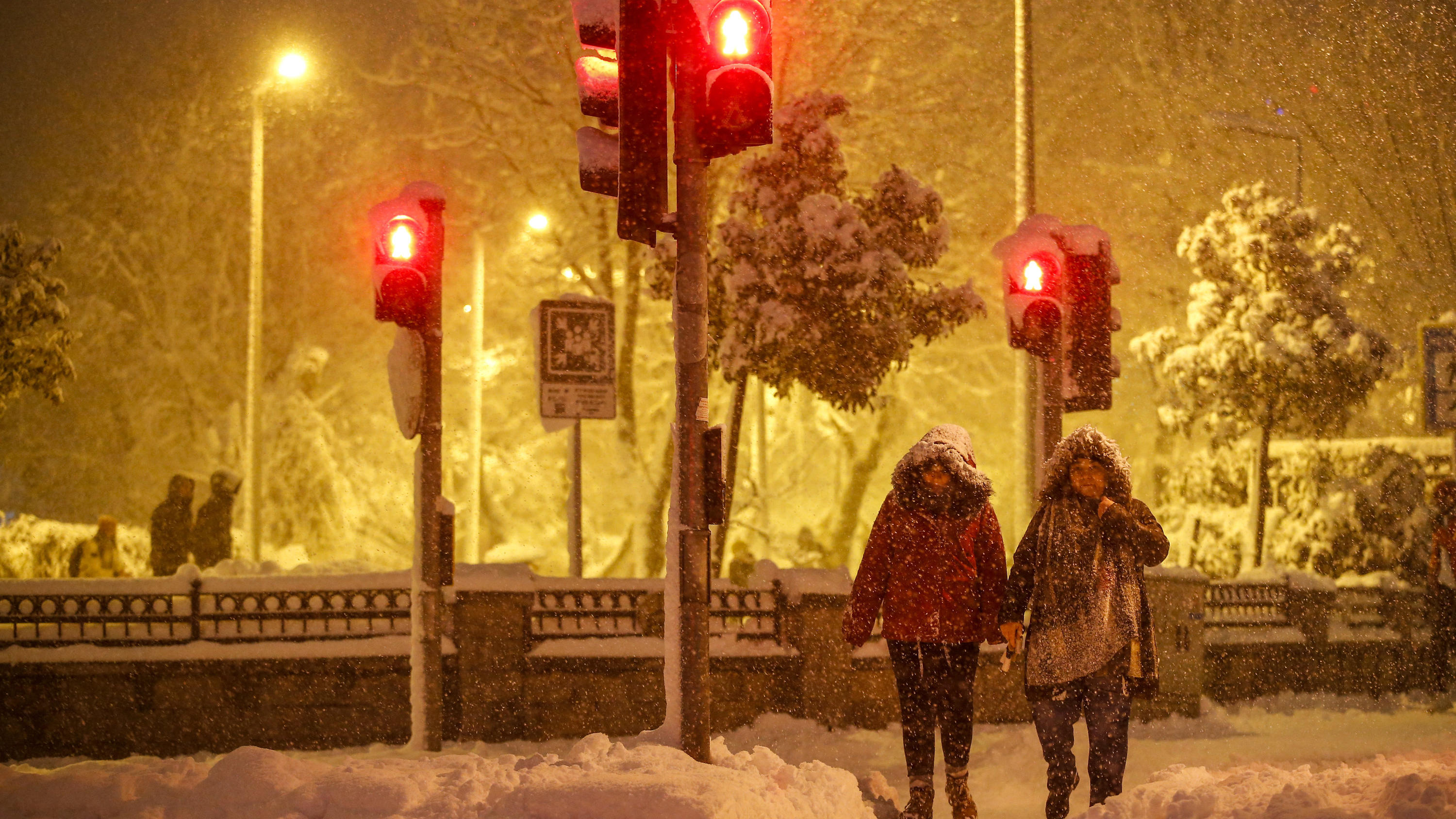 Pedestrians walk during snow fall in Istanbul, Turkey, on Monday, Jan. 24, 2022. A severe snowstorm disrupted road and air traffic Monday in the Greek capital of Athens and in neighboring Turkey's largest city of Istanbul, while snow blanketed most of Turkey and Greece, including several Aegean islands. (AP Photo/Emrah Gurel)