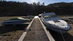 Pleasure boats tied to a pier rest on dry ground of the water depleted Zezere River due to drought, near Figueiro dos Vinhos in central Portugal, Thursday, Feb. 17, 2022. Portugal has seen little rain since last October. By the end of January, 45f the country was enduring "severe" or "extreme" drought conditions, according to the national weather agency IPMA. (AP Photo/Sergio Azenha)
