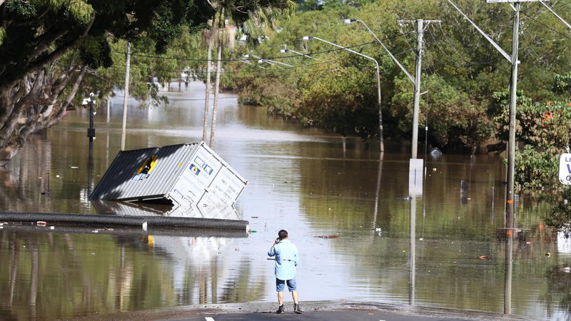 A man stands in front of a flooded street following heavy rains in Lismore, New South Wales, Australia March 2, 2022. AAP Image/Jason O'Brien via REUTERS  ATTENTION EDITORS - THIS IMAGE WAS PROVIDED BY A THIRD PARTY. NO RESALES. NO ARCHIVE. AUSTRALIA