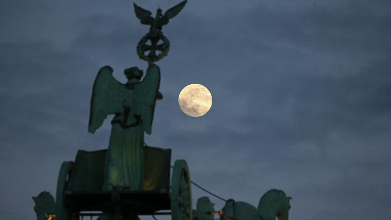 15.02.2022, Berlin: Der Vollmond geht hinter dem Adler und Ehrenkranz der Quadriga, die auf dem Brandenburger Tor steht, auf. Nach Angaben der Meteorologen werden in den kommenden Tagen die Sterne und der Mond nicht am Nachthimmel zu sehen sein, da S