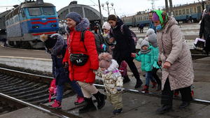 Refugees fleeing the ongoing Russian invasion of Ukraine cross the tracks after arriving on a train from Kyiv region at the train station in Lviv, Ukraine, March 8, 2022. REUTERS/Kai Pfaffenbach