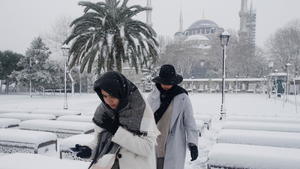 People, with the Sultanahmet Mosque, known as the Blue Mosque in the background, walk during a snow storm in Istanbul, Turkey March 11, 2022. REUTERS/Dilara Senkaya