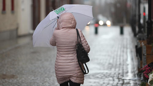 07.04.2022, Sachsen-Anhalt, Wernigerode: Eine Frau geht mit Regenschirm durch die Stadt. Ein Sturm- und Regengebiet zieht am Donnerstag über Mitteldeutschland. Foto: Matthias Bein/dpa +++ dpa-Bildfunk +++