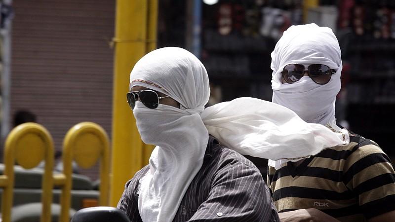 Indian commuters protect themselves with cotton clothes from scorching heat in Bhopal in Madhya Pradesh, India on 27 May 2010. Many parts of north and east India continued to reel under a heat wave and water shortage with the mercury nearing a scorch