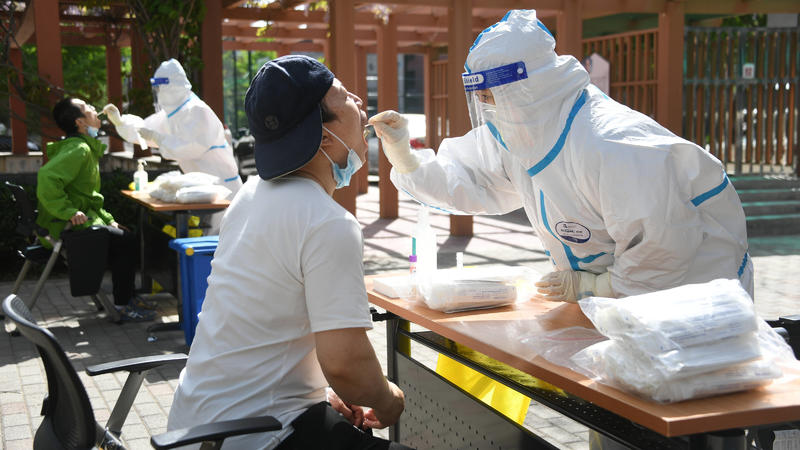  220426 -- BEIJING, April 26, 2022 -- A medical worker takes a swab sample from a citizen at a makeshift nucleic acid testing site during a mass testing for COVID-19 in Haidian District, Beijing, capital of China, April 26, 2022. Beijing will conduct